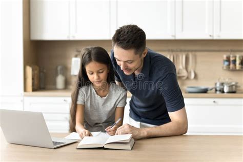 Positive Caring Young Dad Helping Daughter Schoolkid with Homework Task ...