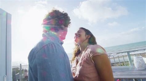 4k / Ultra HD version Romantic couple share a kiss on balcony with view of the beach in the background. In slow motion. Shot on RED Epic