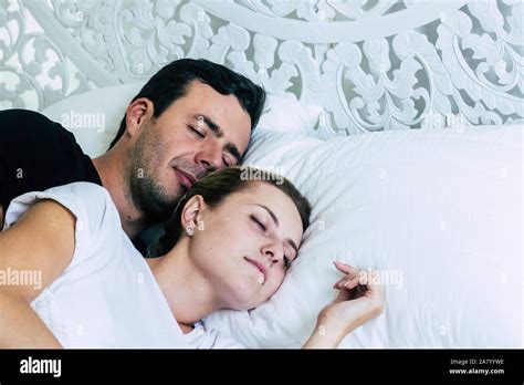 Tender caucasian young couple sleep together in hotel room or at home ...