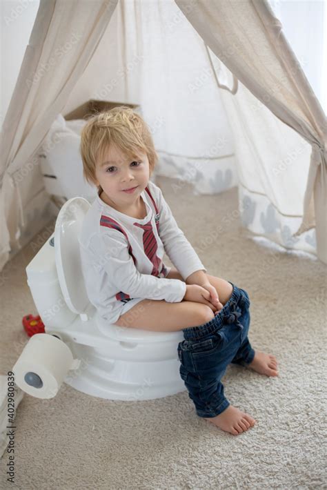 Cute toddler child, boy, sitting on a baby toilet potty, playing Stock ...