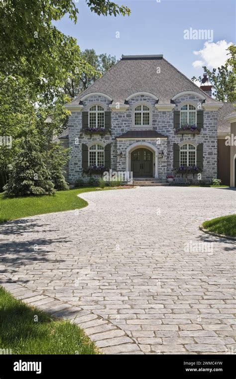 French Manor style natural stone home with paving stone driveway Stock ...