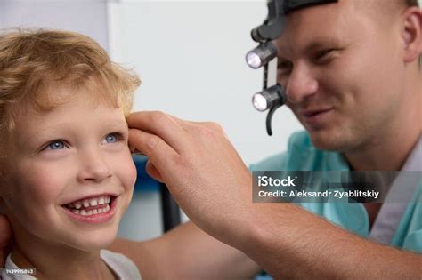 Funny Boy Smiles While A Kind Doctor Checks His Ears For Ear Plugs ...