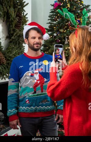 Smiling Couple In Sweaters And Santa Helper Hats Stock Photo Alamy