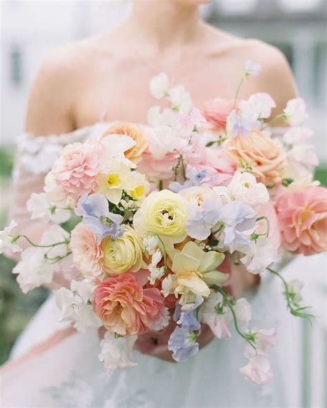 A Woman Holding A Bouquet Of Flowers In Her Hands And Wearing A White