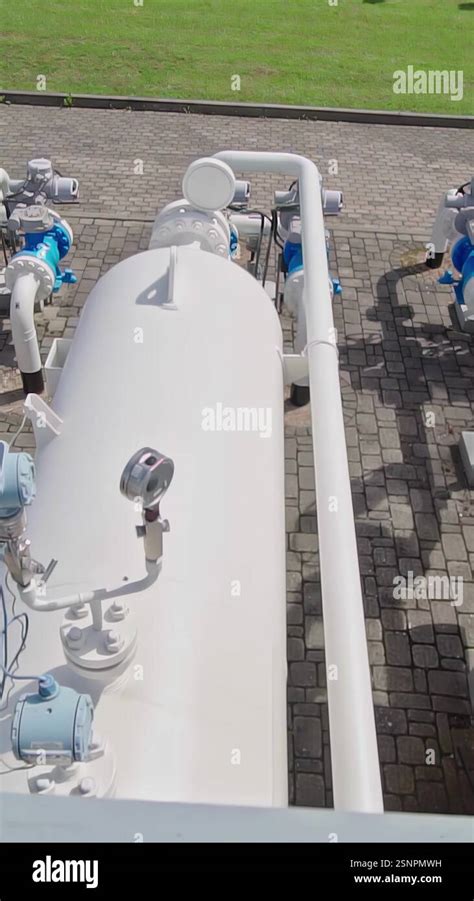 Industrial Natural Gas Station With White And Blue Pipelines On A Paved