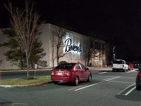 Cars Are Parked In Front Of A Retail Store At Night With The Lights On