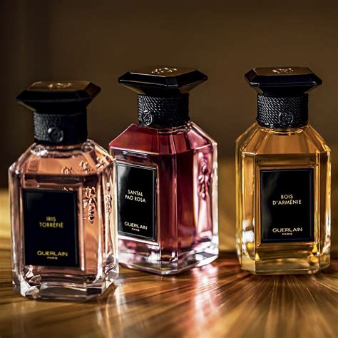 Three Bottles Of Perfume Sitting On Top Of A Wooden Table