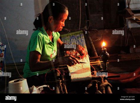 A Woman Working With Patterns For Traditional Woven Fabrics At The