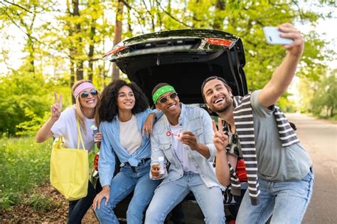 Premium Photo Group Of Friends Making Selfie In The Forest While Sitting On The Car Boot