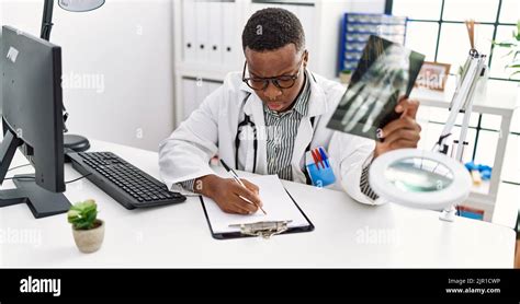 Young African Man Working As Doctor Looking At Hand Xray At Medical