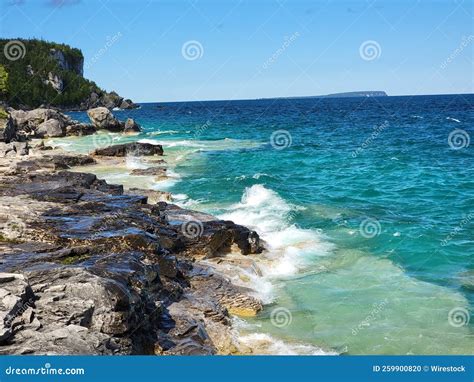 Beautiful Shot Of Foamy Sea Waves Splashing Against A Rocky Shore Stock