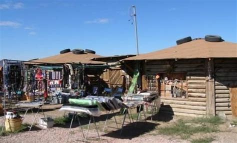 There Are Many Tents And Chairs Outside In The Dirt Near A Building