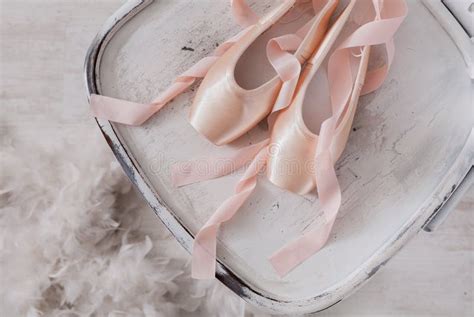 Pink Ballet Pointe Shoes And Feather On White Wood Background Stock