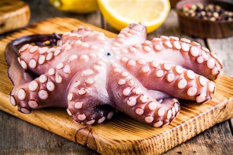 Pulpo Crudo Fresco Entero En Tabla De Cortar Con La Sal Del Mar Foto De