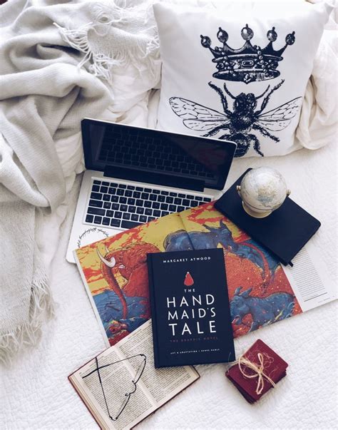 A Laptop Computer Sitting On Top Of A Bed Next To Books And Other Items