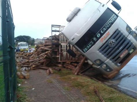 Caminhão carregado 47 toneladas de eucalipto tomba em rotatória na