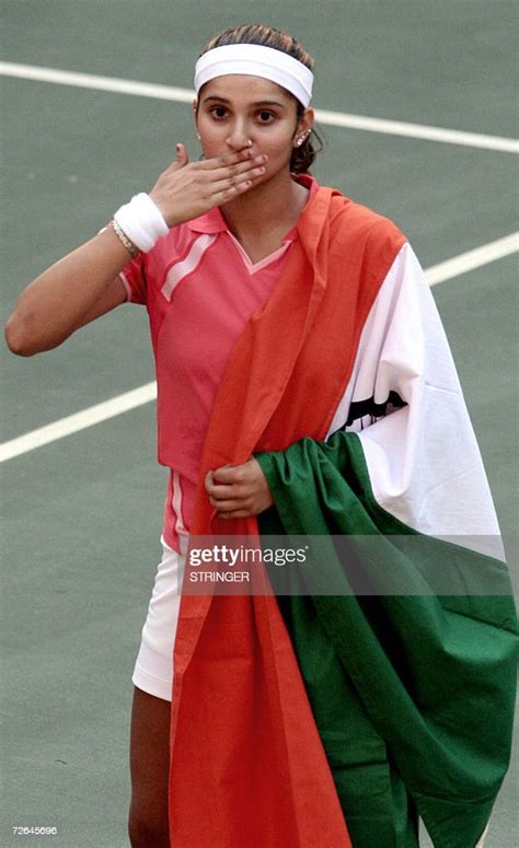 Indian tennis player Sania Mirza draped in an Indian flag, blows a ...