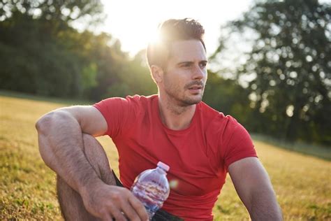 Premium Photo Man Looking Away While Sitting On Field