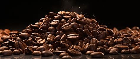 Premium Ai Image Coffee Beans Cascade Onto A Mound Of Beans