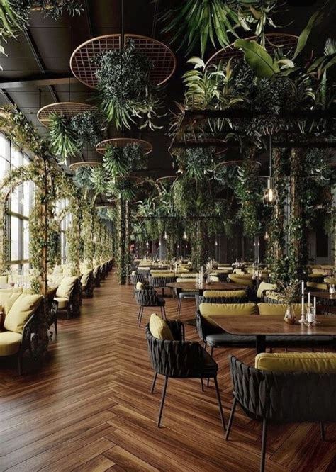 An Indoor Restaurant With Tables And Chairs Covered In Plants