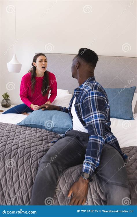 Sad Diverse Couple Sitting On Bed Arguing At Home Stock Image Image