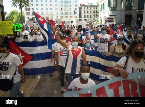 Protesters Seen Marching And Holding Cuban Flags As They Take Part In A