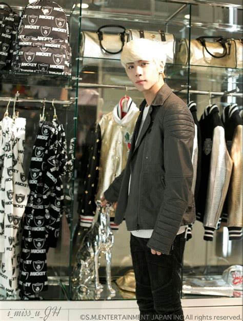 A Man Standing In Front Of A Display Case Filled With Shirts And