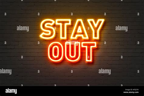 Stay out neon sign on brick wall background Stock Photo - Alamy