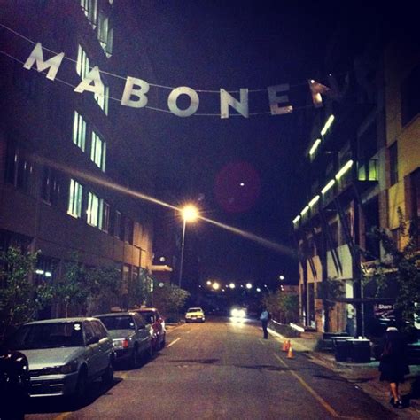 Cars Parked On The Side Of A Street Under A Sign That Reads Mabonee