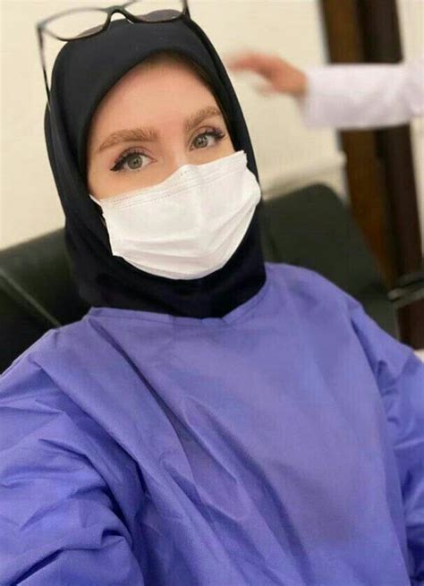 A Woman Wearing A Surgical Mask Sitting In A Chair With Her Hand Out To