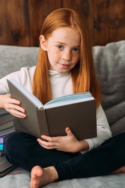 Premium Photo A Redhaired Girl With A Book In Her Hands Sits In The