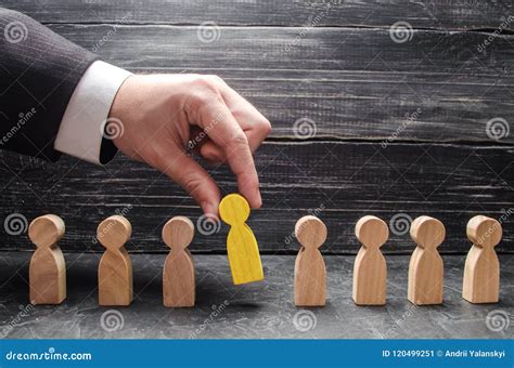 Hand Of A Businessman Takes A Wooden Figure Of A Man Stock Image