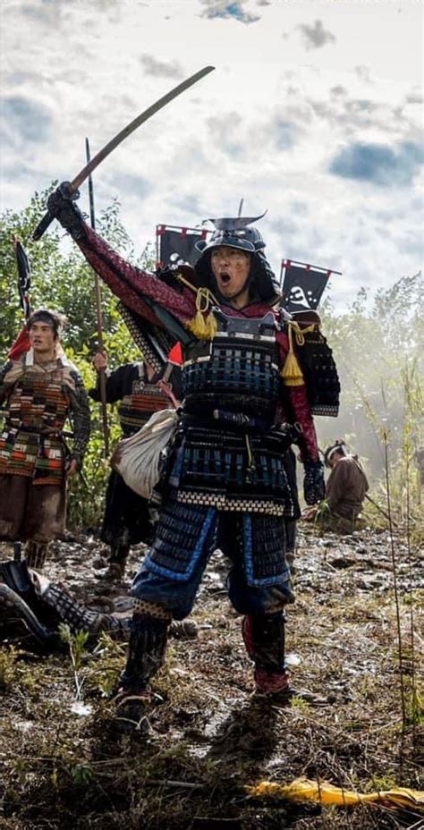 A Group Of Men Dressed In Japanese Armor And Holding Swords Walking