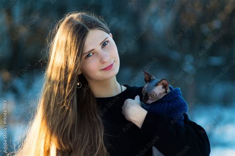 Young Pretty Girl With Her Pussy In Her Arms In The Winter Park On A Bright Day Cat Breed