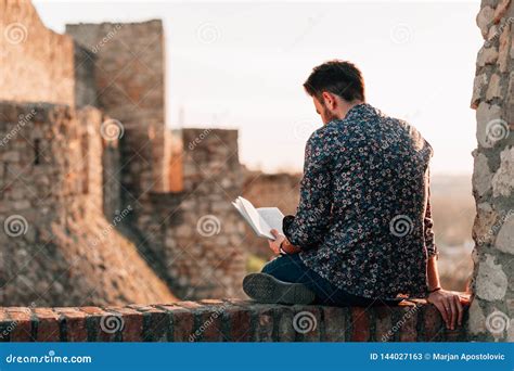 Young Man Reading a Book Outdoors Stock Image - Image of read, casual ...