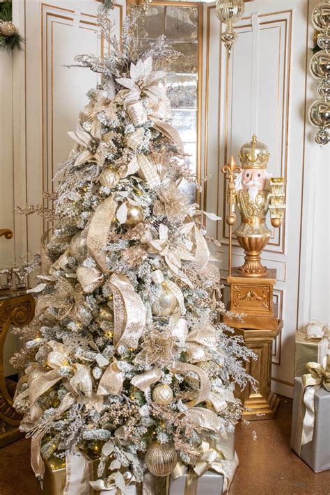 A White Christmas Tree With Gold And Silver Decorations