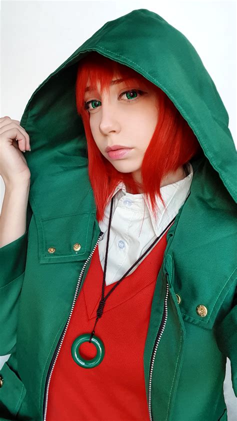 a woman with red hair wearing a green jacket