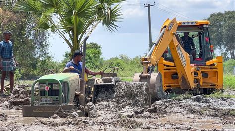 JCB 3DX Pulling Out John Deere 5039D Cage Wheel Tractor Stuck In Mud