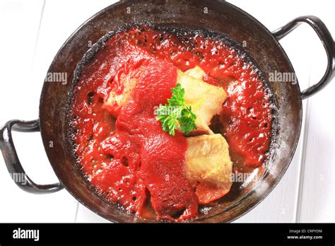 Pan fried fish fillets in rich tomato sauce Stock Photo - Alamy