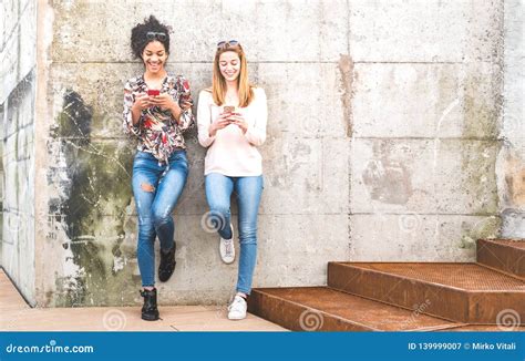 Happy Girls Best Friends Having Fun Outdoors With Mobile Smart Phone Friendship Concept With