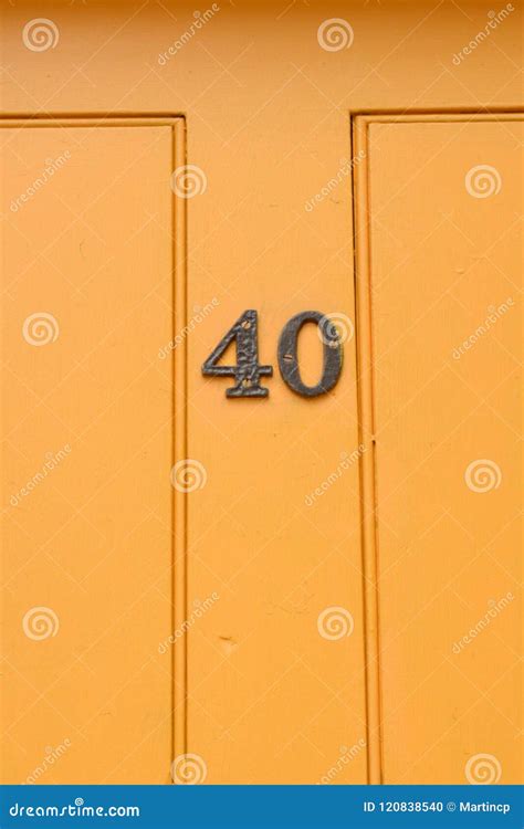 House Number 40 Sign On Bright Yellow Painted Wooden Door Stock Photo