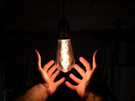 Premium Photo Midsection Of Person Holding Light Bulb