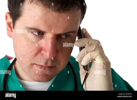 Man Wearing Medical Scrubs And Stethoscope Holding Mobile Phone To His