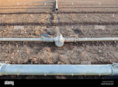 Irrigation Metal Pipes Connections On Recently Seeded Field Closeup