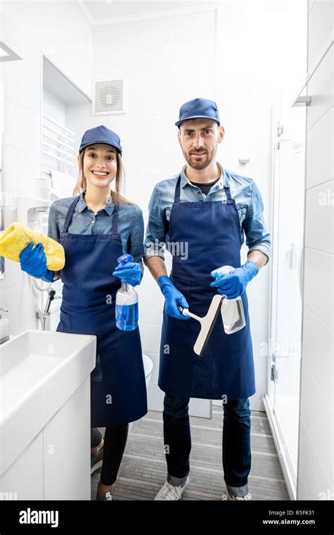 Portrait Of A Young Couple As A Professional Cleaners In Blue Uniform