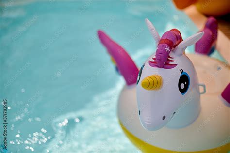 Inflatable colorful white unicorn at the swimming pool. Vacation time ...