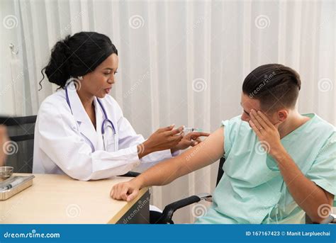 African Female Doctor Injection To The Male Patient Hand Press Syringe