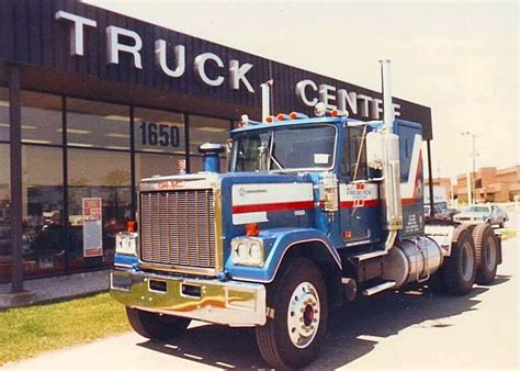 A Large Blue Truck Parked In Front Of A Building