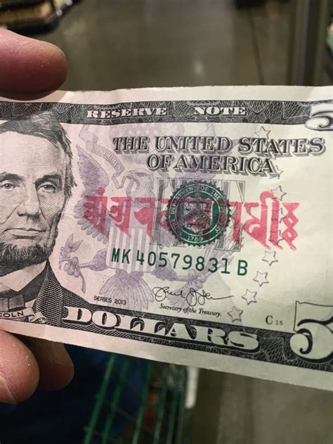 some red symbols on a five dollar bill. asked around and nobody could figure out what language ...