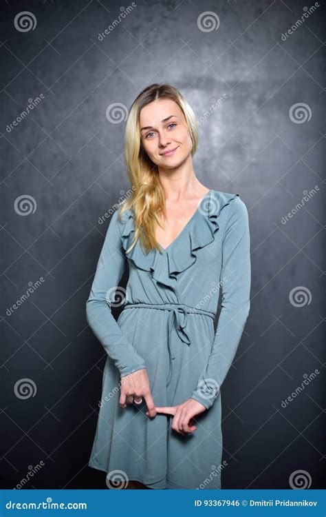 Modest Blonde Girl On A Gray Wall Background Stock Photo Image Of